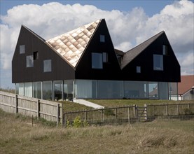 Sunshine shining on metal roof of modern house on the seafront at Thorpeness, Suffolk, England,