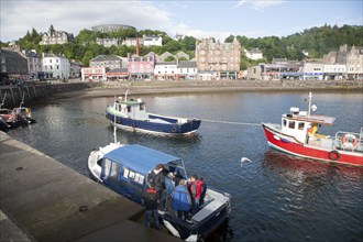 Fishing boats and small passenger foot ferry in the harbour at the town of Oban, Argyll and Bute,