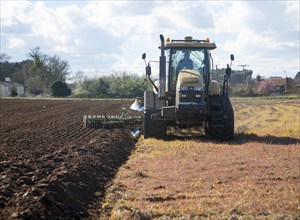 Challenger tracked tractor ploughing and pressing the soil in an arable field, Butley, Suffolk,