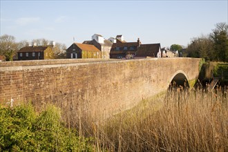 Reed beds by bridge and maltings buildings, River Alde, Snape, Suffolk, England, United Kingdom,