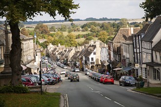 Tourist honeypot village street crowded with traffic in Burford, Oxfordshire, England, UK