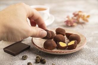 Japanese rice sweet buns chocolate mochi filled with cream and cup of green tea and hand on brown