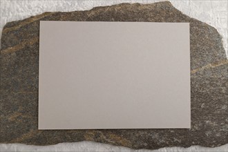 Beige paper business card, mockup with natural stone on gray concrete background. Blank, flat lay,