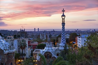 City view, building with colourful mosaics, Park Güell entrance, dawn, in front of sunrise,