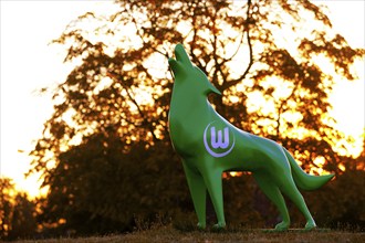 Green wolf sculpture with VfL Wolfsburg logo at sunset, Wolfsburg, Lower Saxony, Germany, Europe