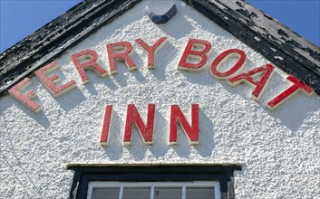 Red lettering detail of pub sign Ferry Boat Inn, Felixstowe Ferry, Suffolk, England, UK