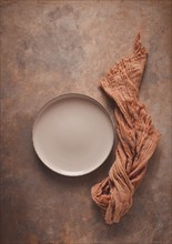 Beige plate, empty, on a beige-brown background, rust effect, no people