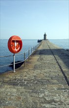 Red life saving ring on harbour breakwater, St Peter Port, Guernsey, Channel Islands, UK, Europe