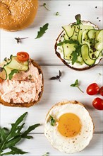 Assortment of sandwiches, white bread, fried egg, cream cheese and cucumber, capelin caviar, sesame