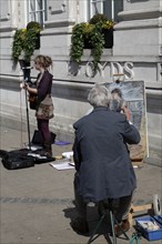 Street artist painting woman busker, Norwich, England, United Kingdom, Europe