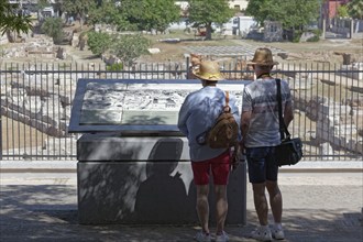 Two tourists looking at a plan of the excavation site, Kerameikos, ancient cemetery, Athens,