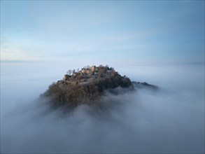 Aerial view of the Hegau volcano Hohentwiel with the upper fortress ruins in front of sunrise,