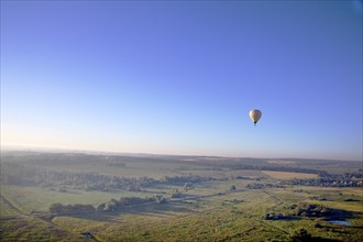 Balloon fly over field at sunrise