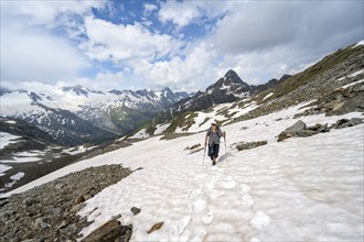 Mountaineer crossing a snowfield, ascent to the Nördliche Mörchnerscharte, mountain peak with snow