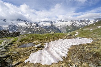 Picturesque mountain landscape with snowfield, mountain peaks with snow and glacier