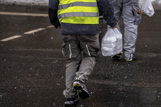 Winter in Frankfurt, worker of a large construction site has bought lunch for himself and