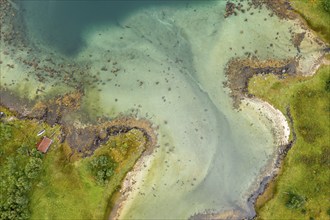 Aerial view of a bay at the Raftsund, single hut with boat, fjord between Lofoten and Vesteralen,