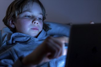 A boy plays computer games on a tablet PC