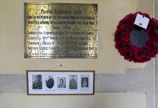 Village war memorial remembrance with names photographs poppy wreath, Boyton church, Suffolk,