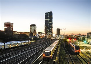 Sunset at the Modersohn Bridge, view of railway tracks, trains and the 140 metre high Amazon office