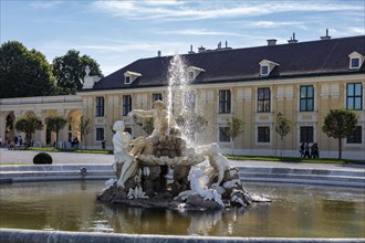 Spectacular baroque fountain in front of historic building in the park, Vienna