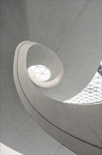 Modern architecture with a spiral design and natural lighting through a geometric glass skylight,