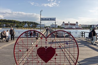 Red heart with castles on a pier with a view of the Seebad Binz building, Rügen, Binz