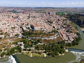 Aerial view of a historic city with a river, several bridges and prominent buildings on hills,