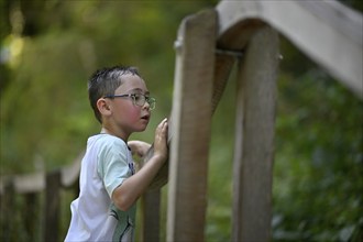 Child, boy aged 5, multi-ethnic, playing with marbles on XXL marble run, NATURATUM adventure forest