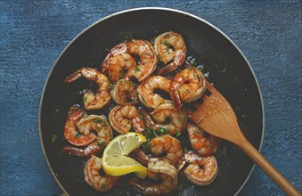 Fried tiger prawns, jumbo, in garlic sauce, in butter, with herbs, in a frying pan, homemade, no