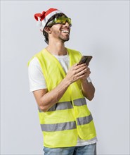 Happy Engineer in christmas hat using cell phone isolated. Smiling engineer in christmas hat using