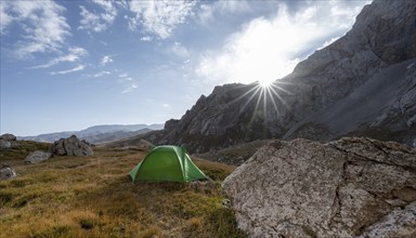 Wild camping, camping in the wilderness with a tent in front of mountain lake Kol Suu, Sary Beles