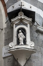 Shrine with a statue of the Virgin Mary on a corner house in the historic centre, Genoa, Italy,