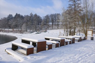 Rest area with snow-covered benches at the Hennesee, Hennetalsperre, Naturpark