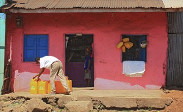 South Ethiopia, street scene in Jinka, yellow canisters in front of a pink house, Ethiopia, Africa