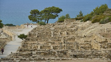 Remains of an ancient city overlooking the sea, surrounded by vegetation, Hellenistic houses,