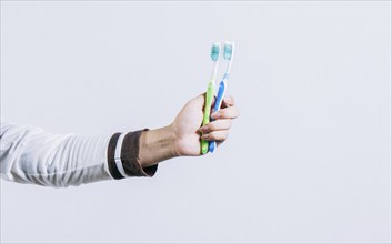 Toothbrush change concept. Hand holding two toothbrushes isolated. Oral health concept