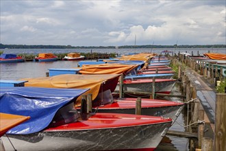 Colourful boats anchored at a wooden jetty, under a cloudy sky, Bad Zwischenahn, Zwischenahner