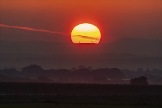 Sunrise, in the background the mountains of the Swabian Alb with wind turbines. Stuttgart,