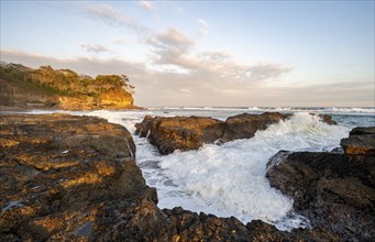 Waves crashing against rocks, Playa Cocalito, coastal landscape at sunset, Pacific coast, Nicoya