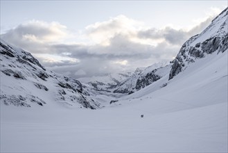 Ski tourer in lonely landscape, snowy mountain landscape, view into Iffigtal, cloudy mood, high