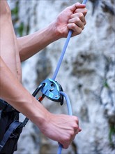 Climber belaying with the Grigri belay device, Belove Stene climbing area, island of Krk, Croatia,