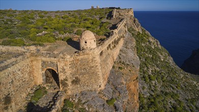 Drone shot, A stony section of a former fortress along a cliff edge overlooking the sea, Venetian