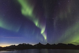 Northern Lights, Aurora borealis over a fjord with steep mountains, autumn, Tasiilaq, East