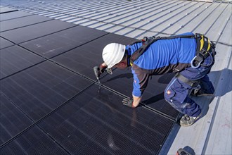 Installation of solar modules on the roof of a commercial enterprise, over 400 photovoltaic modules