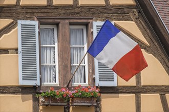 Historic half-timbered house with the French national flag, Colmar, Alsace, France, Europe