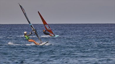 Two people windsurfing on the open sea under a clear sky, windsurfer, Meltemi windsurfing spot,