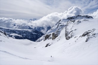 Lone ski tourer descending in fresh snow, mountain landscape in winter, Bernese Alps, Switzerland,