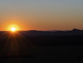 Sunset over the Kellerwald national park in autumn, with the town of Waldeck church and surrounding