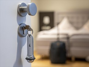 Symbolic image of a hotel, key inserted in the door of a hotel room, analogue lock